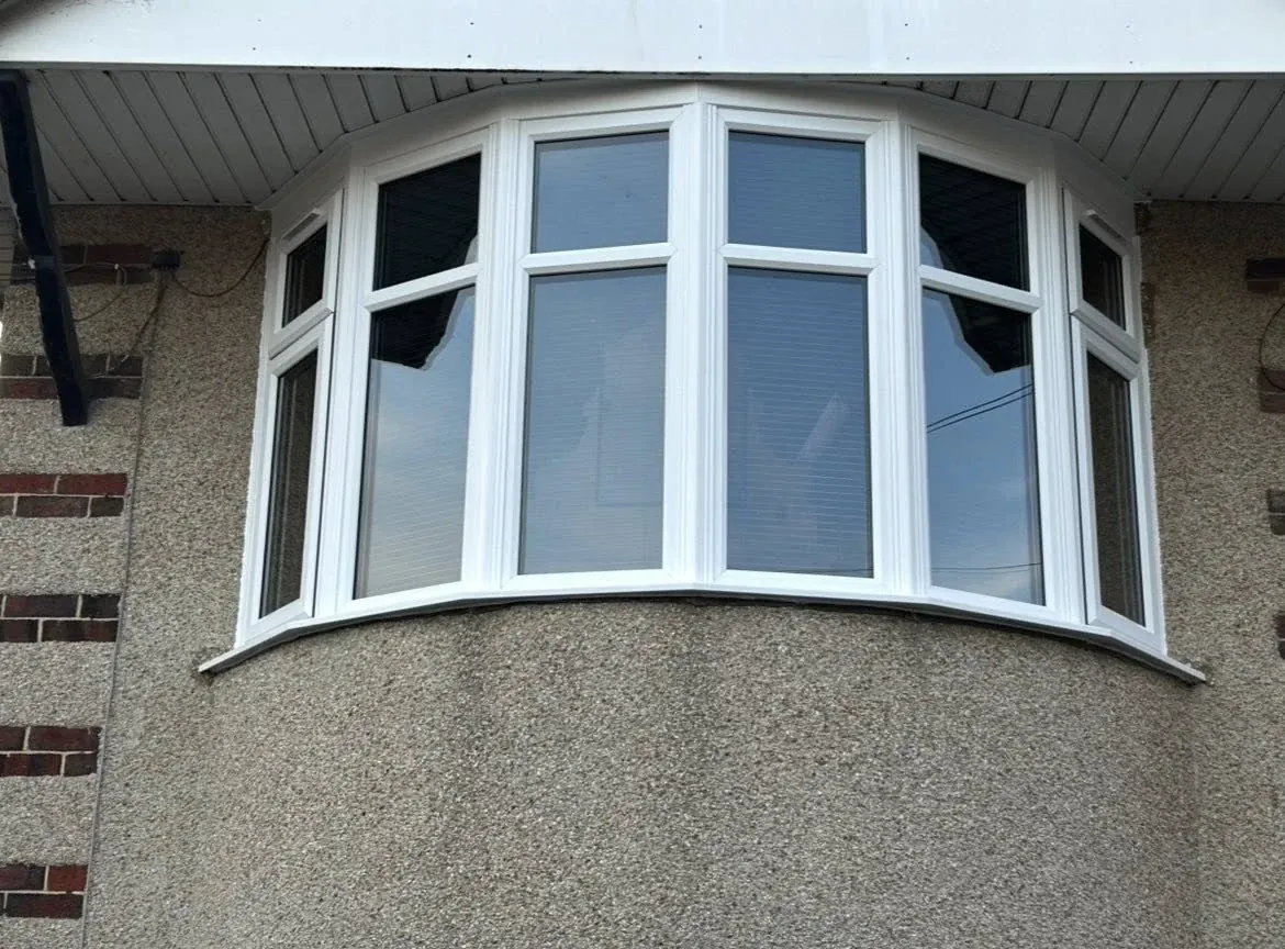 White curved bay window on a rendered house