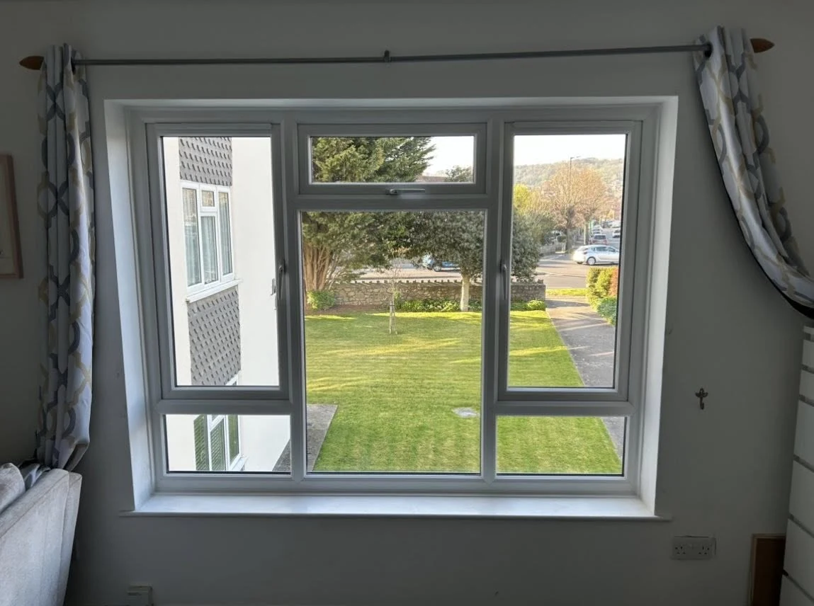 White bedroom window overlooking a garden