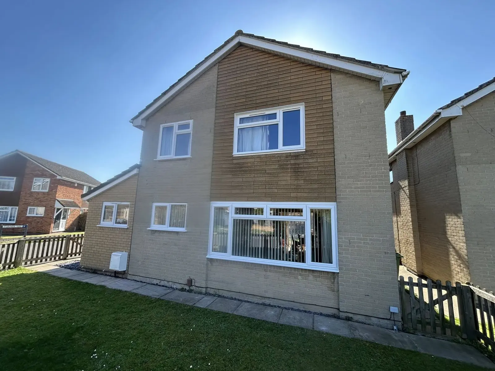 White casement windows on a detached rendered house
