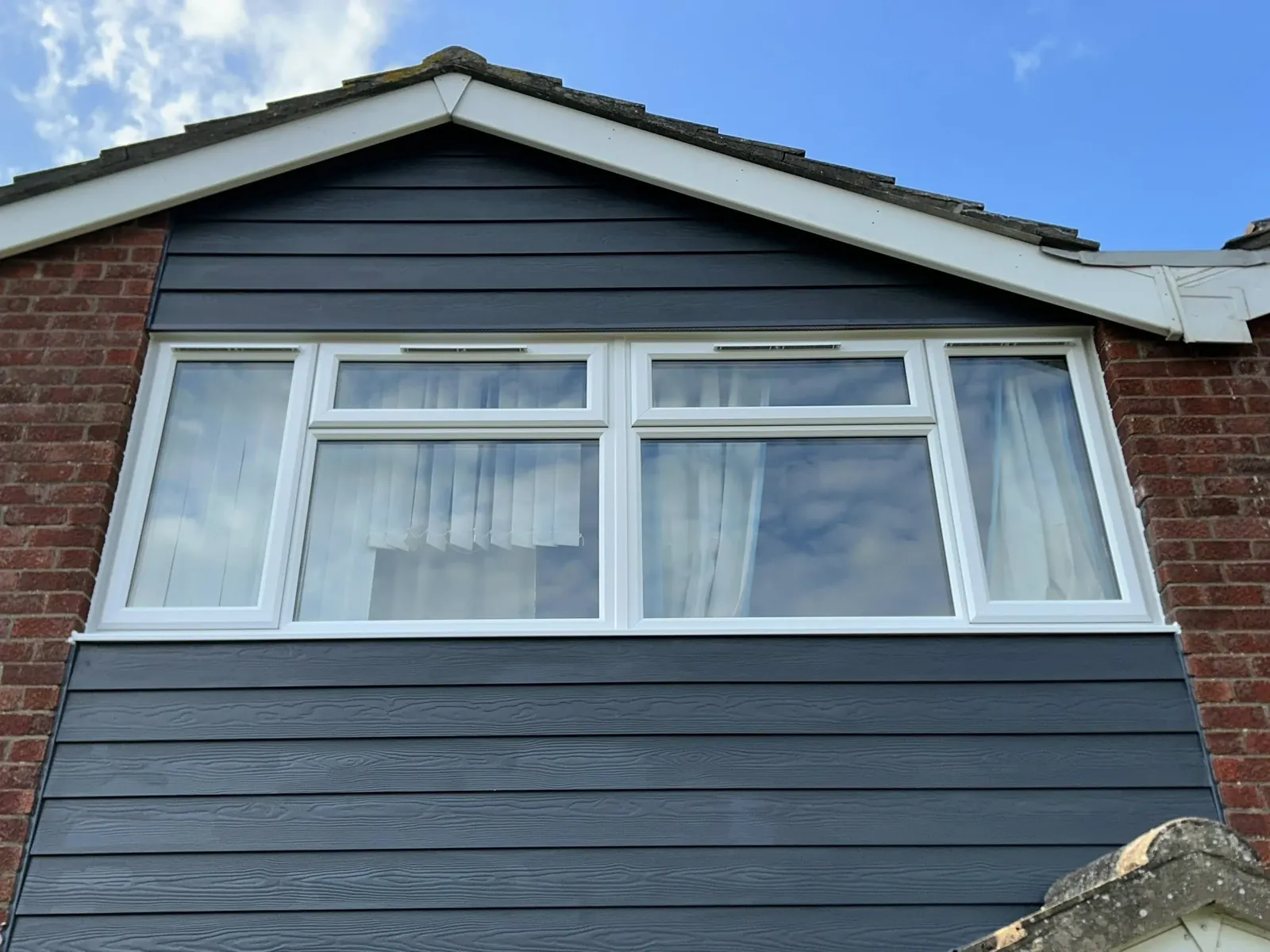 White window in a grey-clad gable